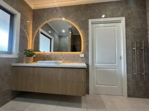 Modern bathroom vanity with arched backlit mirror
