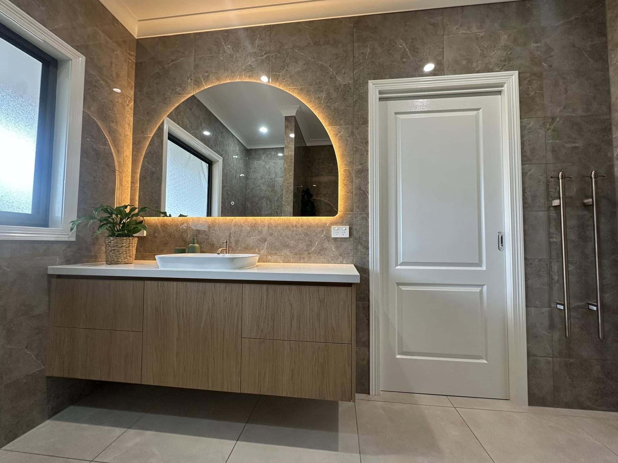 Modern bathroom vanity with arched backlit mirror
