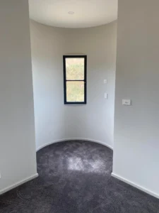 Small curved alcove with narrow window and grey carpet