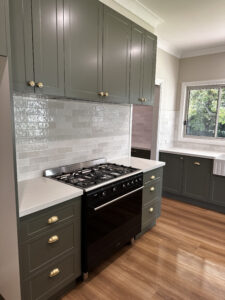 Modern kitchen with sage cabinets and gas stove