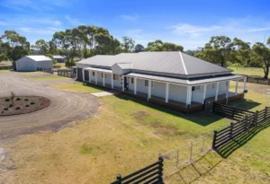 Rural homestead with wraparound verandah and sheds