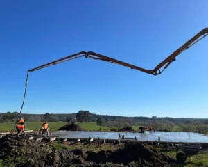 Concrete pump pouring slab in rural field