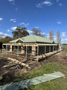 Timber house frame under construction with green roof