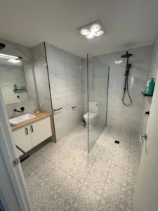 Modern bathroom with patterned tiles and glass shower