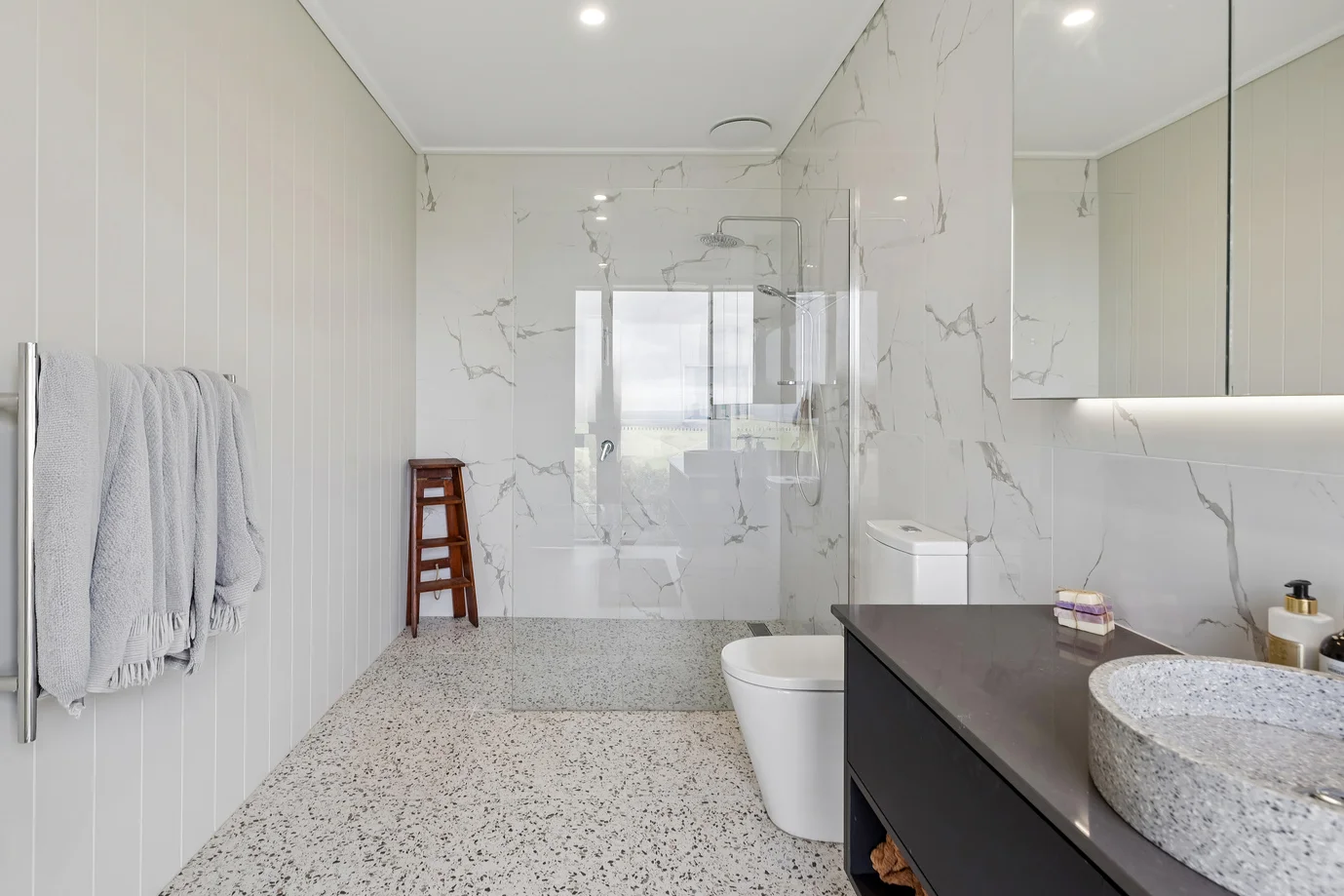 Modern bathroom with marble tiles and glass shower