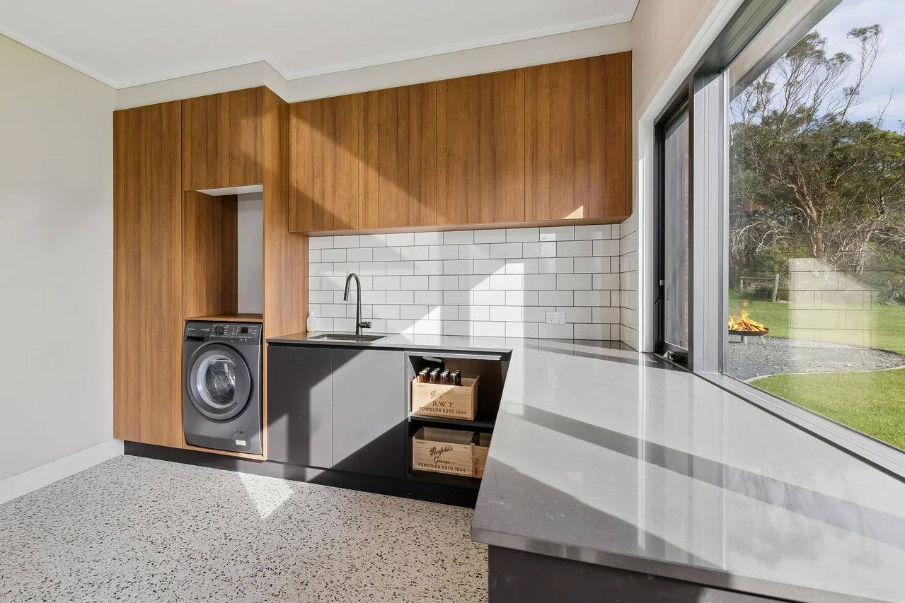 Modern laundry with timber cabinets and large window