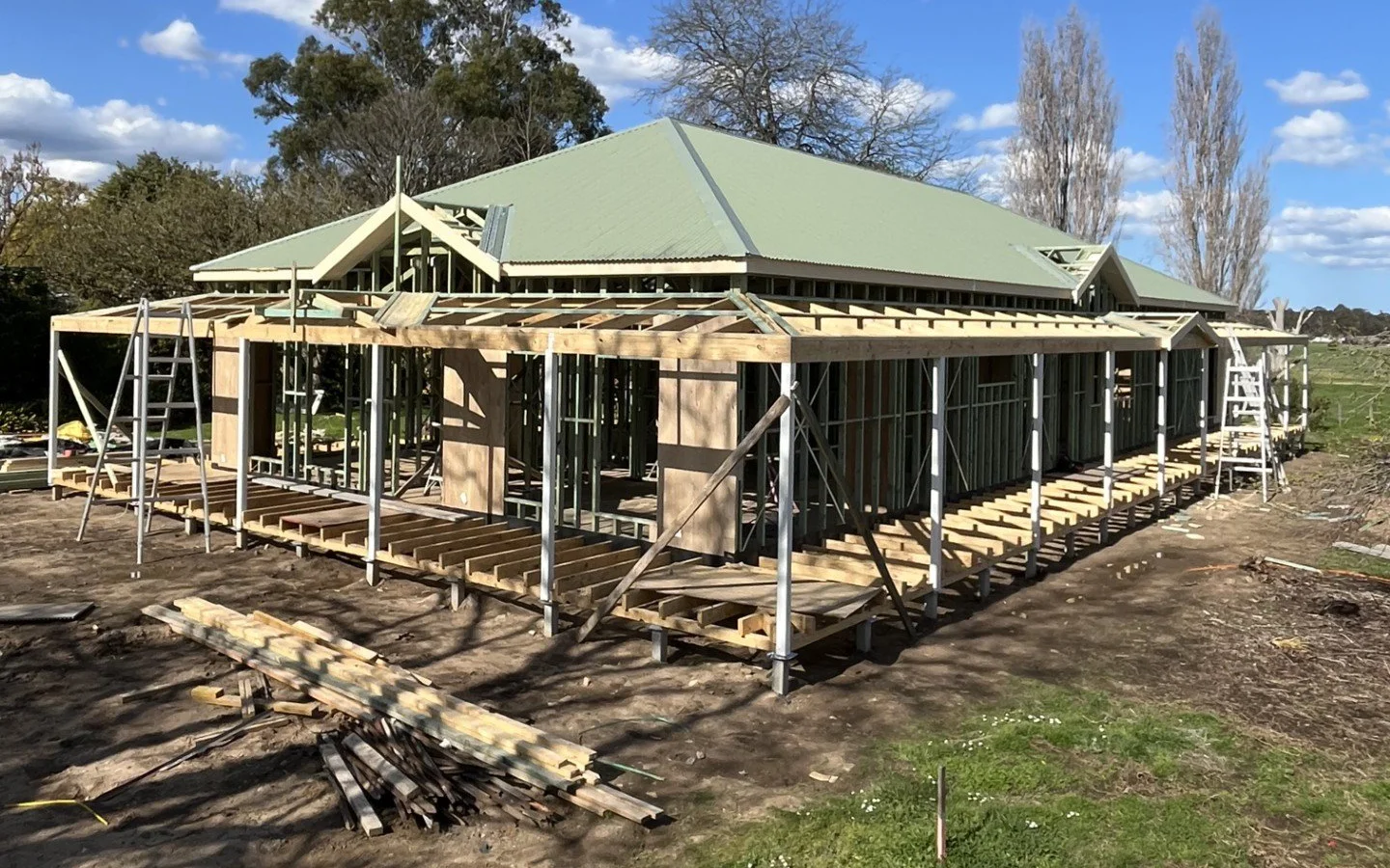 Timber-framed house under construction with green roof
