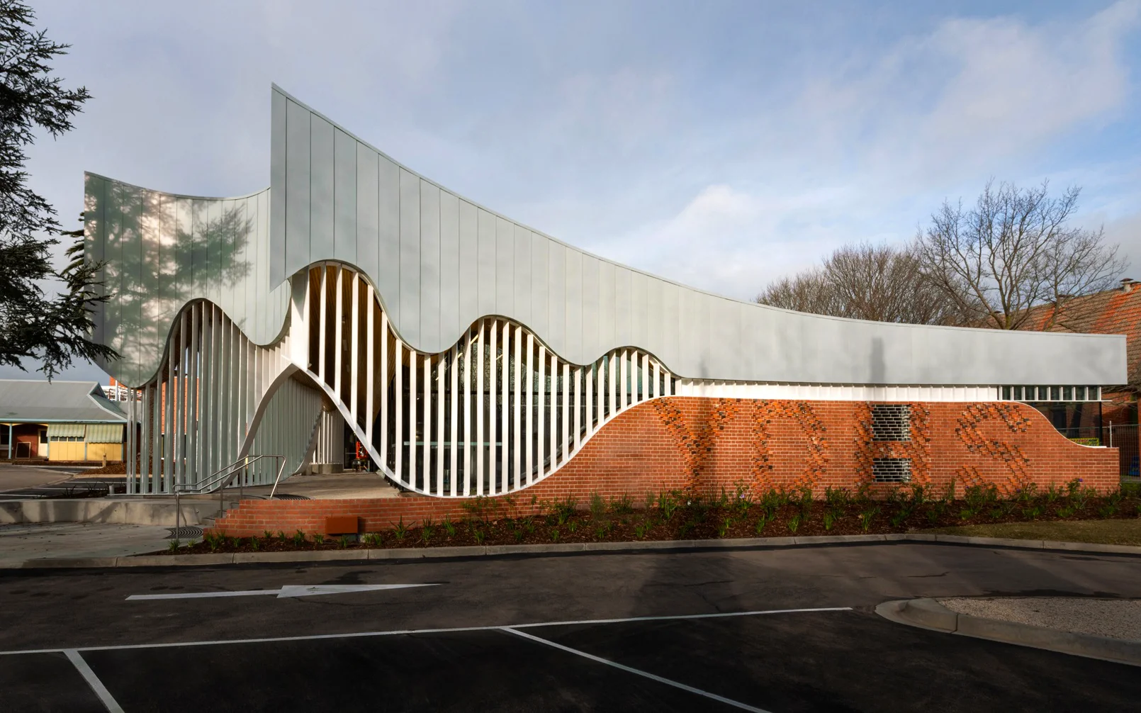 Modern building with curved white facade and brick base